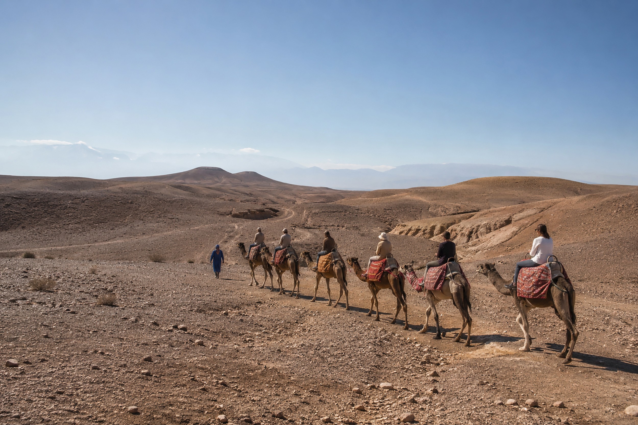 Viaggiatori in dromedario in un paesaggio desertico marocchino