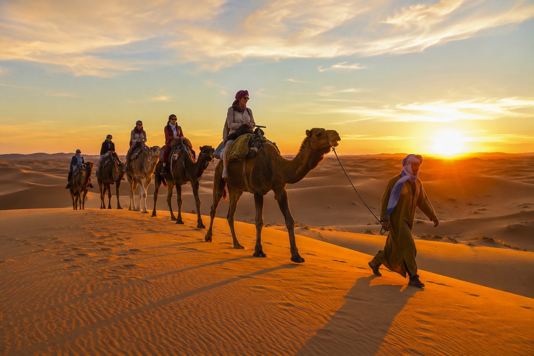 Carovana sulle dune del deserto al tramonto